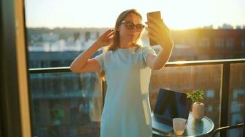 femme travaux sur le balcon contre le toile de fond de le le coucher du soleil. éloigné travail concept video