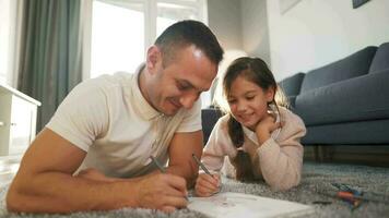 padre y hija son teniendo divertido y pintura juntos. concepto de un contento familia y calidad ocio hora video