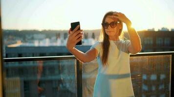 mujer trabajos en el balcón en contra el fondo de el puesta de sol. remoto trabajo concepto video