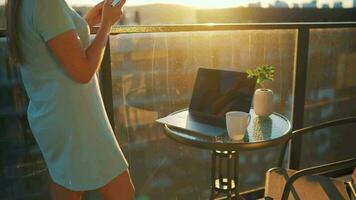 donna lavori su il balcone contro il fondale di il tramonto. a distanza opera concetto video