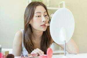 Happy beauty concept, asian young woman, girl make up face hand using eyelash curler on long eyelash before applying mascara brush, looking mirror in morning routine. People look with natural fashion. photo