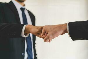 Congrats, business partnership people, two asian and caucasian young man fist bumping, shaking hands together with partnership, customer or colleague after work is done, successful. Worker meeting. photo