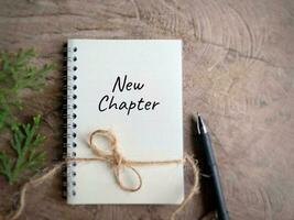 New chapter written on textbook in vintage background. photo