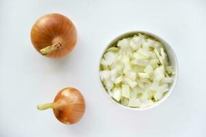 Two onions and chopped onion on a white plate. Onion on a white background. photo