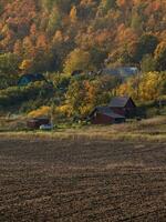 Landscape with farmland ready for planting, with a village on a hill in the background. photo