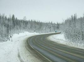 An empty, dirty winter highway. A turn on a slippery road. photo