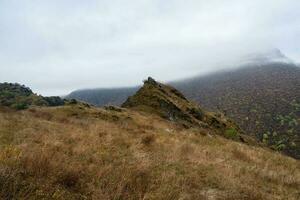 Pointed cliff, a misty mountainside. Ghost rocks. Awesome scenic mountain landscape with big cracked pointed stones closeup in misty morning. Sharp rocks background. photo