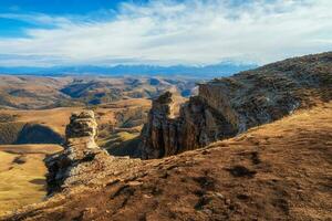 increíble ver de bermamyt meseta rocas en soleado día. Cáucaso montañas en el borde de un acantilado en el distancia. atmosférico paisaje con siluetas de montañas. karachay-cherkesia, Rusia. foto