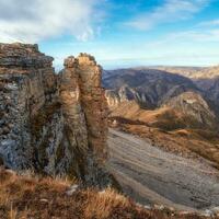 Amazing view of Bermamyt plateau rocks on sunny day. Caucasus Mountains on the edge of a cliff in the distance. Atmospheric landscape with silhouettes of mountains. Karachay-Cherkessia, Russia. photo