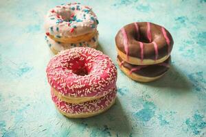 Colorful donuts on blue stone table. Top view photo