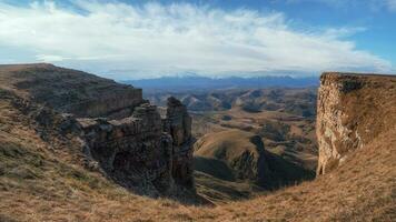 Amazing view of Bermamyt plateau rocks on sunny day. Caucasus Mountains on the edge of a cliff in the distance. Atmospheric landscape with silhouettes of mountains. Karachay-Cherkessia, Russia. photo