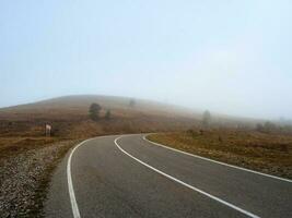 Foggy empty highway up through the pass. Road through a dense fo photo