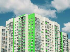 Modern beautiful new high-rise residential building. Colored wall on the background of blue sky. Copy space. photo