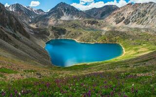 Panoramic view to mountain lake in the shape of a heart. Atmospheric green landscape with lake in high mountain valley. Great scenery with mountain lake in highland glen. photo