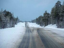 Arctic snow straight winter road through the hills. photo