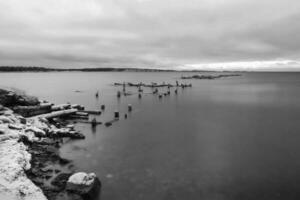 negro y blanco minimalista paisaje con un antiguo arruinado muelle en el ártico foto