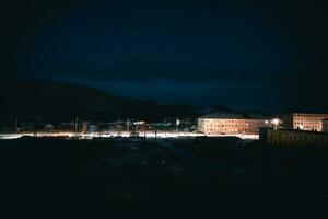 Night view of Arctic village Lodeynoye on the shore of the Barents sea. Empty winter evening  road between. photo