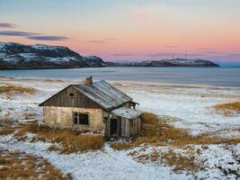 An old house to the attic. Authentic Russian northern village, harsh Arctic nature. Teriberka. photo