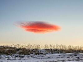 un nube ese mira me gusta un OVNI. lenticular nube encima el suelo foto