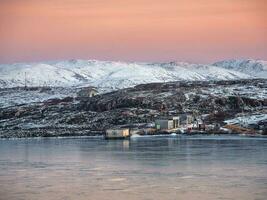 Old fishing lodge on the beach  mountain hard-to-reach lakes in Arctic winter. Northern wildlife. photo