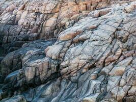 Rock formations - rock layers. Wave texture, a rock formation on the Barents Sea photo