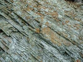 Cross section of rocks. Geological layers. Colored layers of stones in section of the mount, different rock formations and soil layers. photo