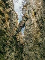 A dangerously overhanging rock in a crevice between the rocks. photo