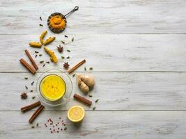 Golden milk with turmeric, cinnamon,ginger, lemon and pepper. Prevention of antiviral infections photo