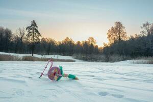 Abandoned broken children's bike in the snow. The end of the holidays concept. photo