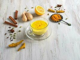 Golden milk with turmeric, cinnamon,ginger, lemon and pepper. Prevention of antiviral infections photo