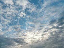 nublado cielo, blanco nubes en un azul cielo. chorro militar avión moscas mediante nubes en un azul cielo. foto