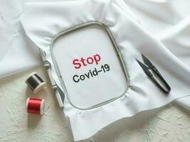 Covid-19 anti coronavirus creative concept. The words are embroidered on a white cloth photo