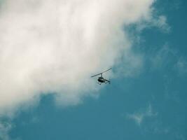 Small helicopter in a cloudy sky. photo