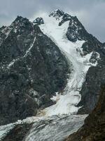 vertical ver de el grande glaciar, alto en el montañas, cubierto por nieve y hielo. altai invierno paisaje. foto