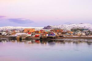 Soft pink halftones of an Arctic village on the shore of the Barents sea. Amazing view of winter Teriberka. Russia photo