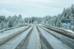 resbaladizo Nevado del Norte invierno camino, giro en el la carretera. kola península. foto