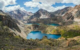 Blue glacial lake high in the mountains. Atmospheric green landscape with a lake in a high-altitude valley. Altai Mountains. photo