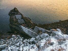 Old rusty fishing boat abandoned by a storm on the shore. photo