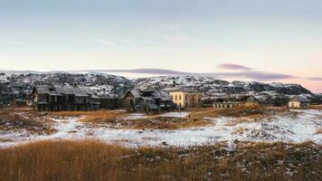 abandonado casas en contra el ártico cielo. antiguo auténtico pueblo de teriberka. kola península. Rusia. foto