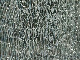 Texture of cracks on a broken glass showcase photo