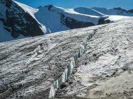 Fault in a glacier, a dangerous crack in the ice on the snowy slope of a glacier. photo