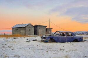 antiguo desmontado coche a el garajes en auténtico pueblo de teriberka. foto