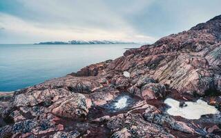 View to big cliff in arctic sky. Minimalist scenery with beautiful rockies. Awesome polar scenery with pointed rock photo