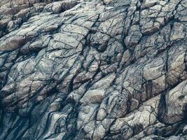 Rock formations - rock layers, close up, monochrome view. Wave texture, a rock formation on the Barents Sea photo