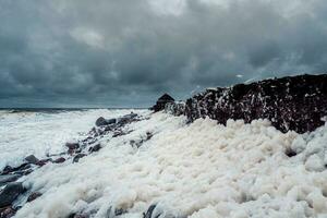 Dramatic minimalistic seascape with waves and white foam on the White sea. photo