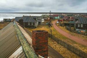 Small authentic village on the White sea coast. Authentic Russian northern village, old wooden houses. Kashkarantsy fishing collective farm. Kola Peninsula. photo