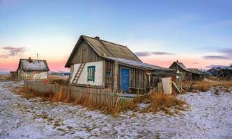 Panoramic view of old house against the Arctic sky. Old authentic village of Teriberka. Kola Peninsula. photo