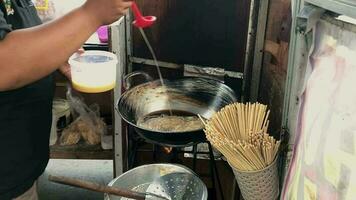 indonesiano strada cibo è chiamato fritte uovo rotoli e può essere trovato su il ciglio della strada. video