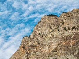 Big rock formation, different rock formations and soil layers. Distant mountain plateau photo