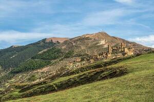 Summer view of ruins and towers of the aul ghost Goor in Dagestan in the evening light. Russia. photo